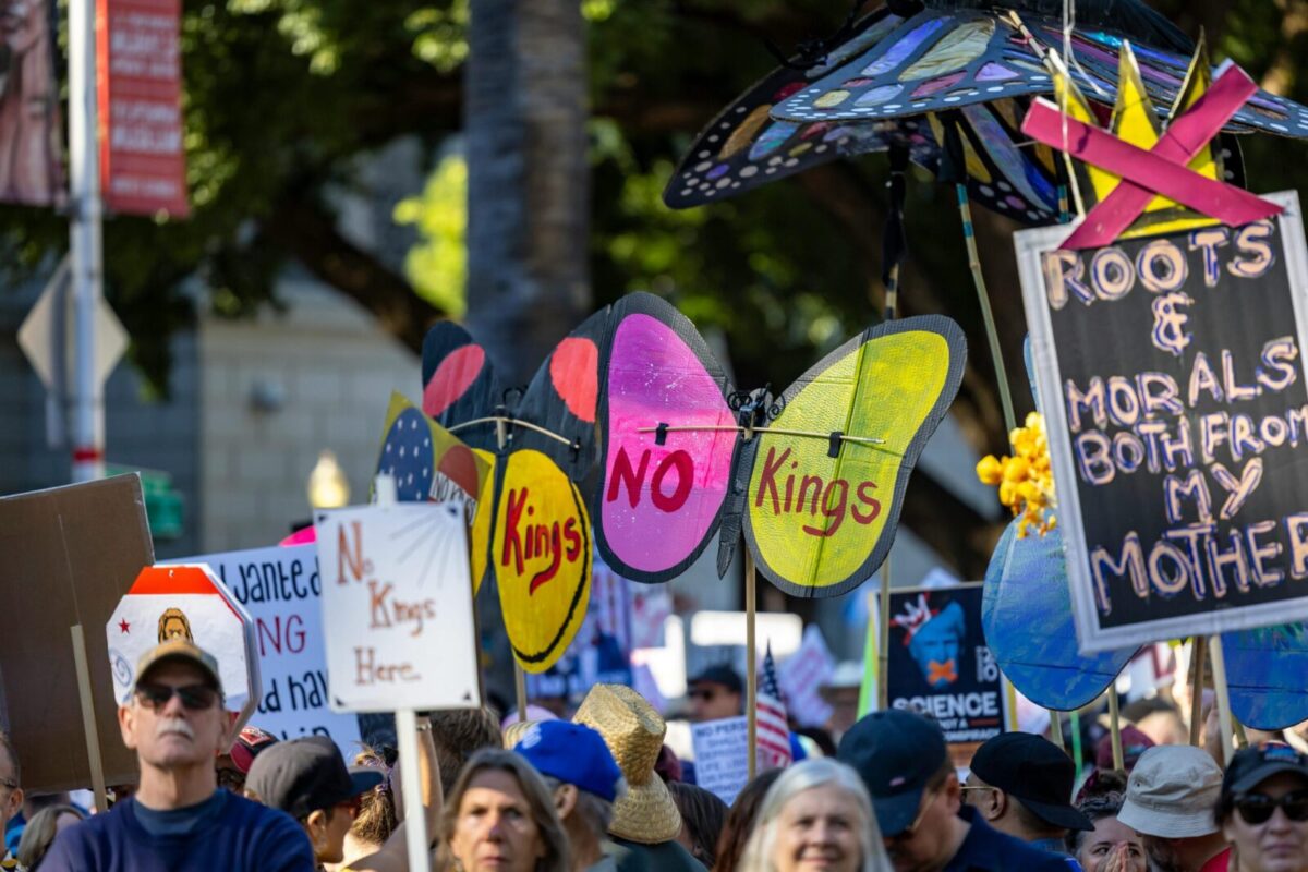 Protesters with vibrant signs at a rally in Sacramento promoting change and expression.