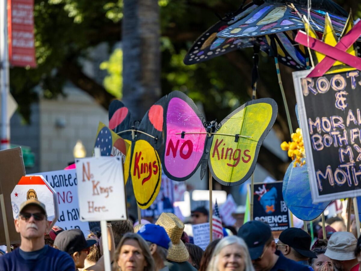 Protesters with vibrant signs at a rally in Sacramento promoting change and expression.
