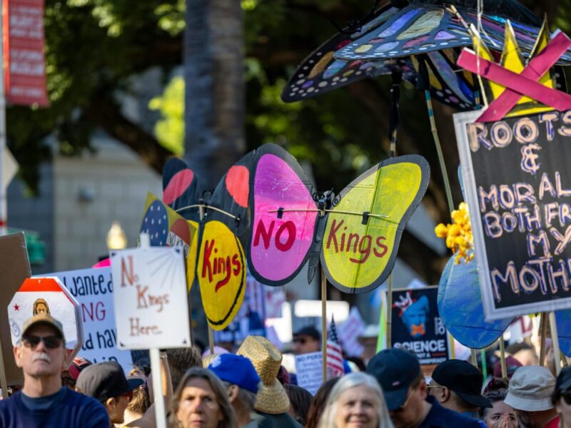 Protesters with vibrant signs at a rally in Sacramento promoting change and expression.