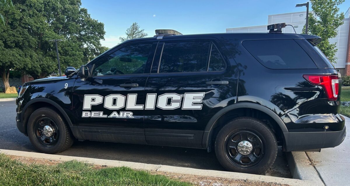 Black Bel Air police SUV parked along a curb on a sunny street.