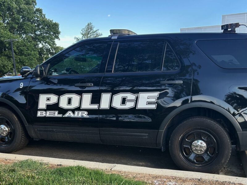 Black Bel Air police SUV parked along a curb on a sunny street.