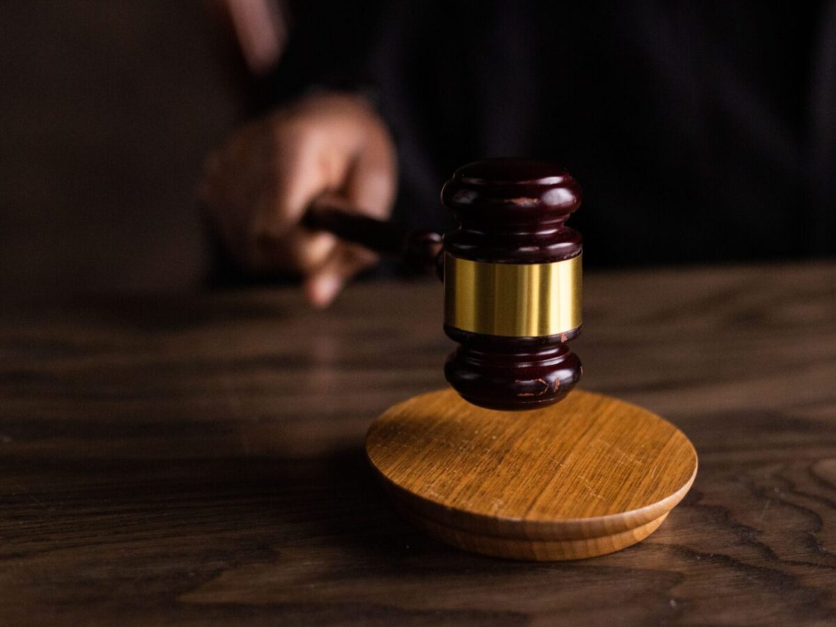 A gavel striking a sound block, symbolizing justice and legal authority in a courtroom setting.