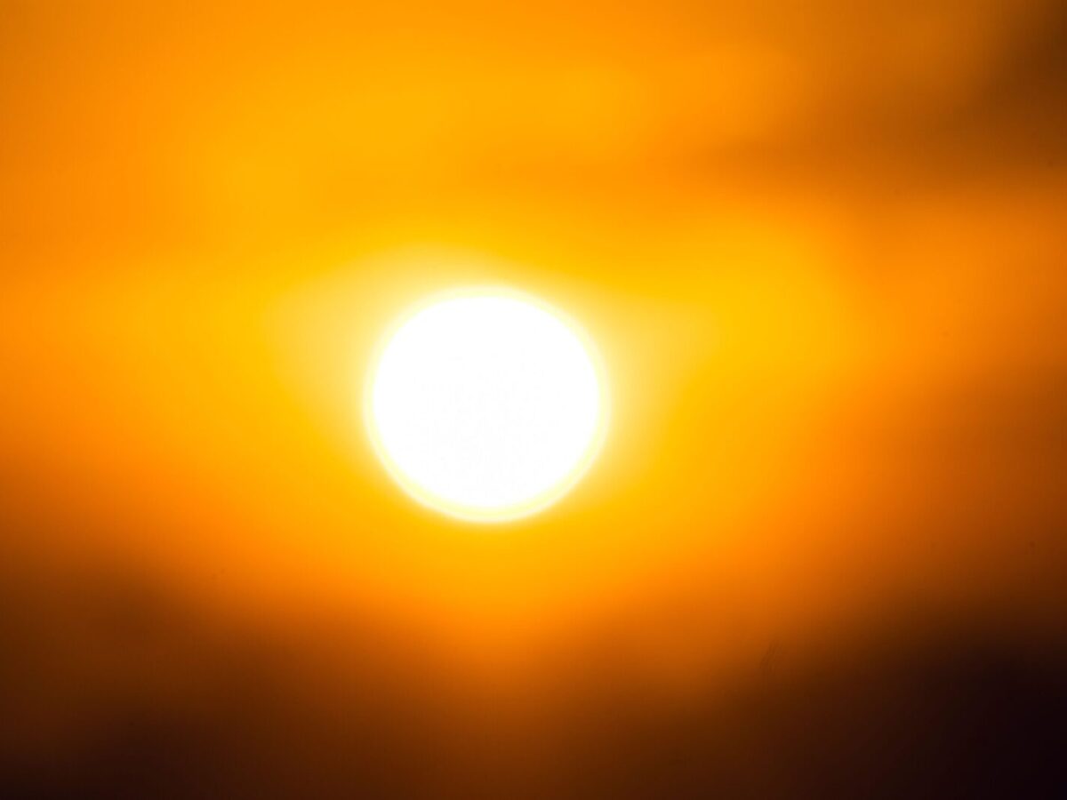 Vivid image of the sun against an orange sky, capturing twilight's essence.