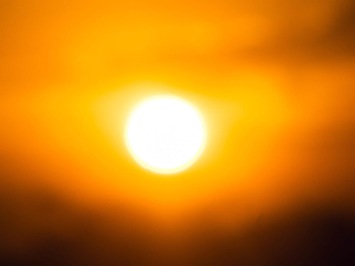 Vivid image of the sun against an orange sky, capturing twilight's essence.