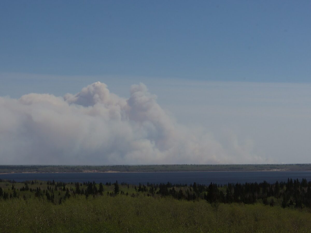 a large plume of smoke rising from a large body of water