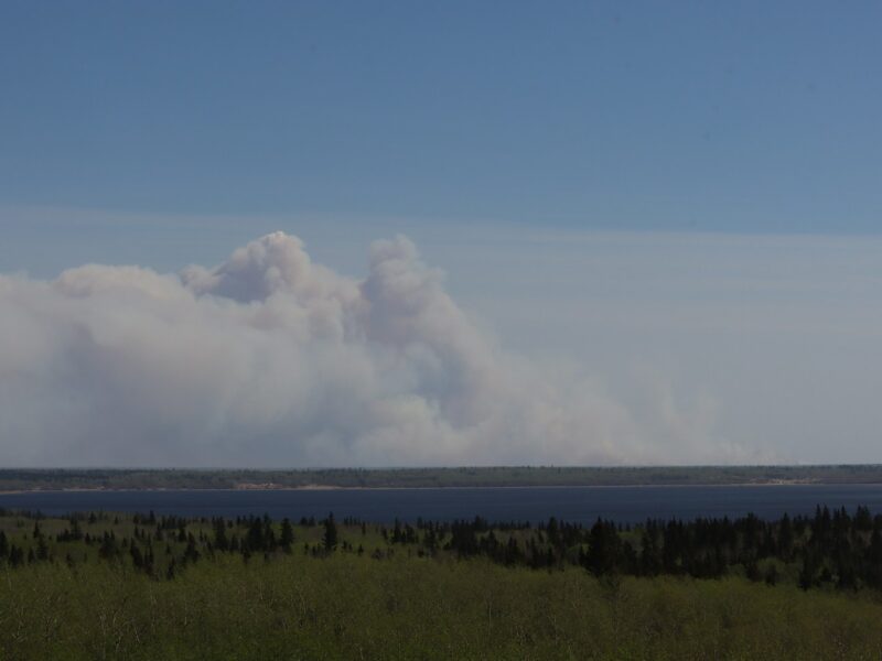 a large plume of smoke rising from a large body of water