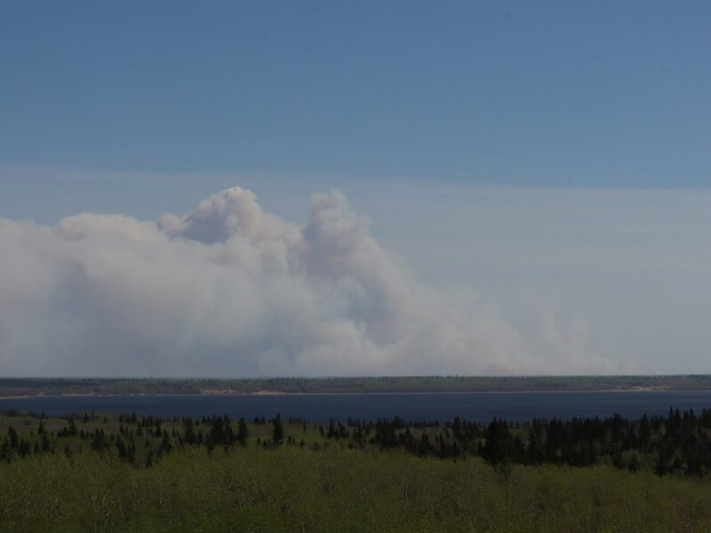 a large plume of smoke rising from a large body of water