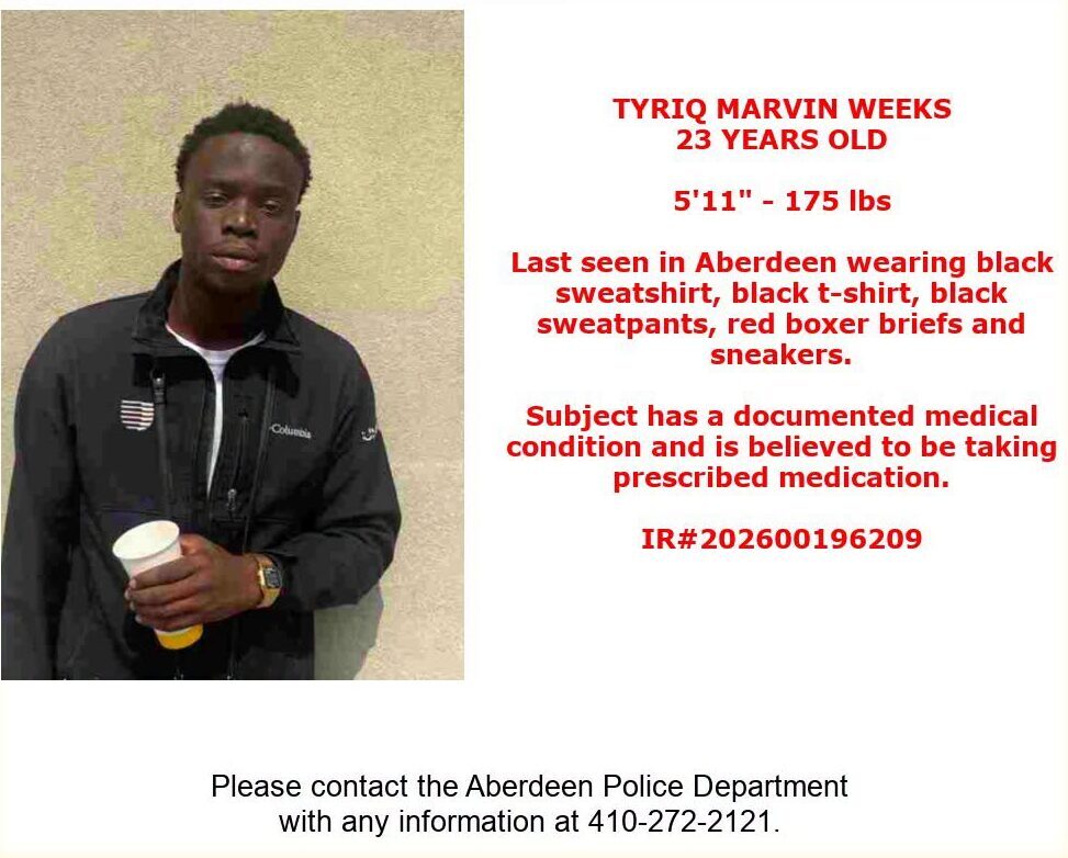 Missing person poster with a man in a black jacket holding a cup beside red text on a white background.