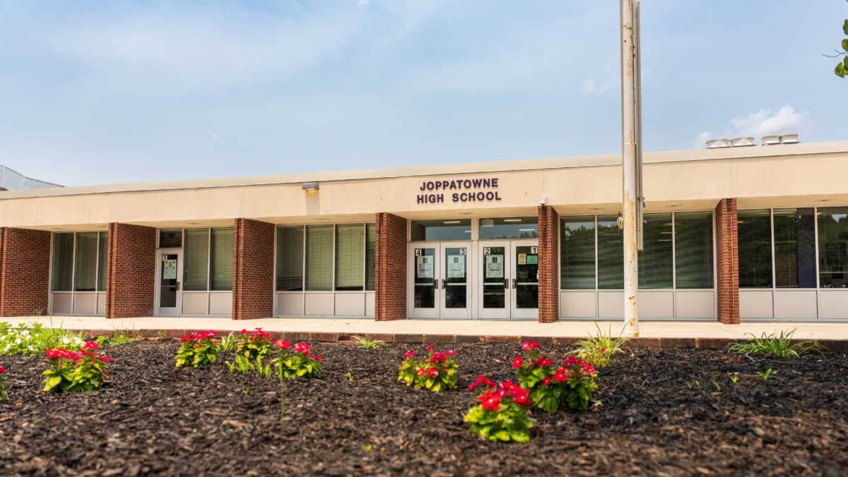 Joppatowne High School entrance with flower beds in front of a low brick building.