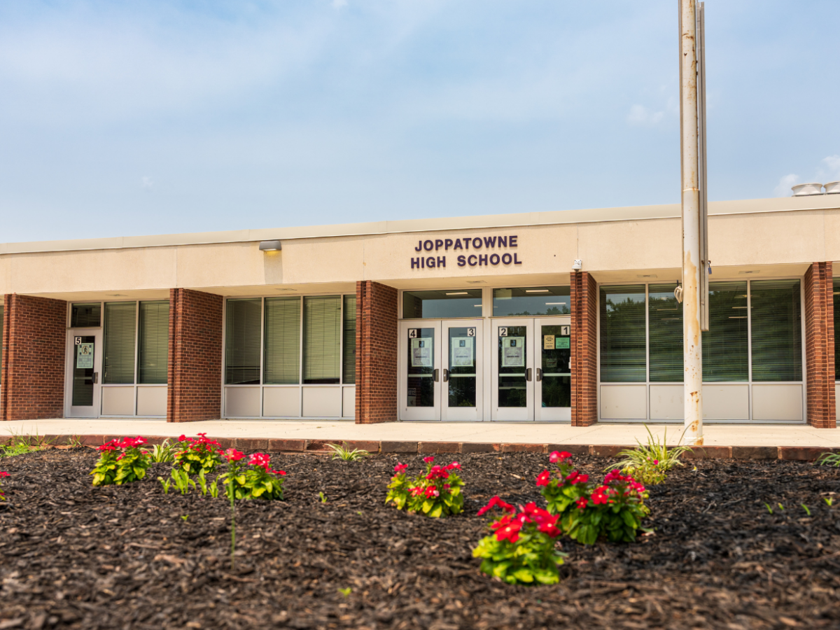 Joppatowne High School entrance with flower beds in front of a low brick building.