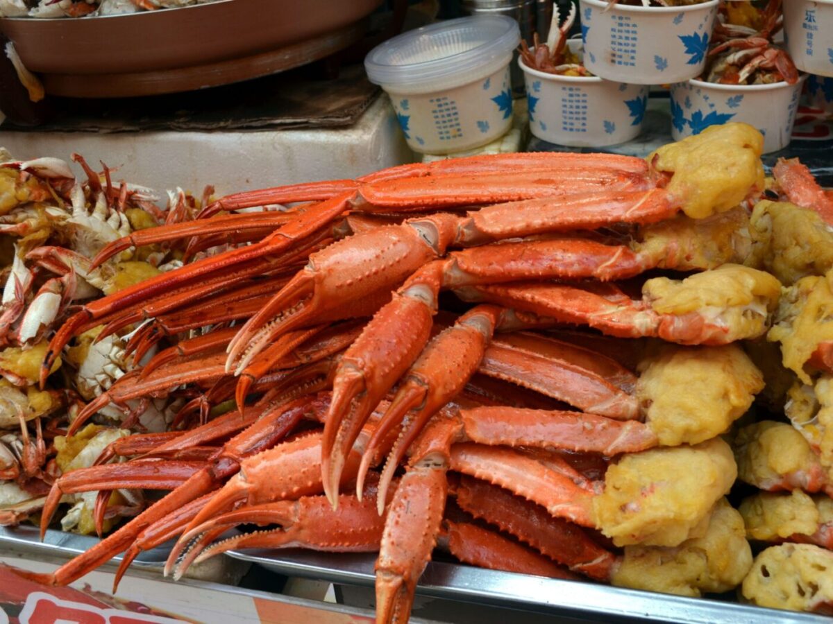 Delicious freshly cooked crab legs displayed at a vibrant street food market, perfect for seafood lovers.
